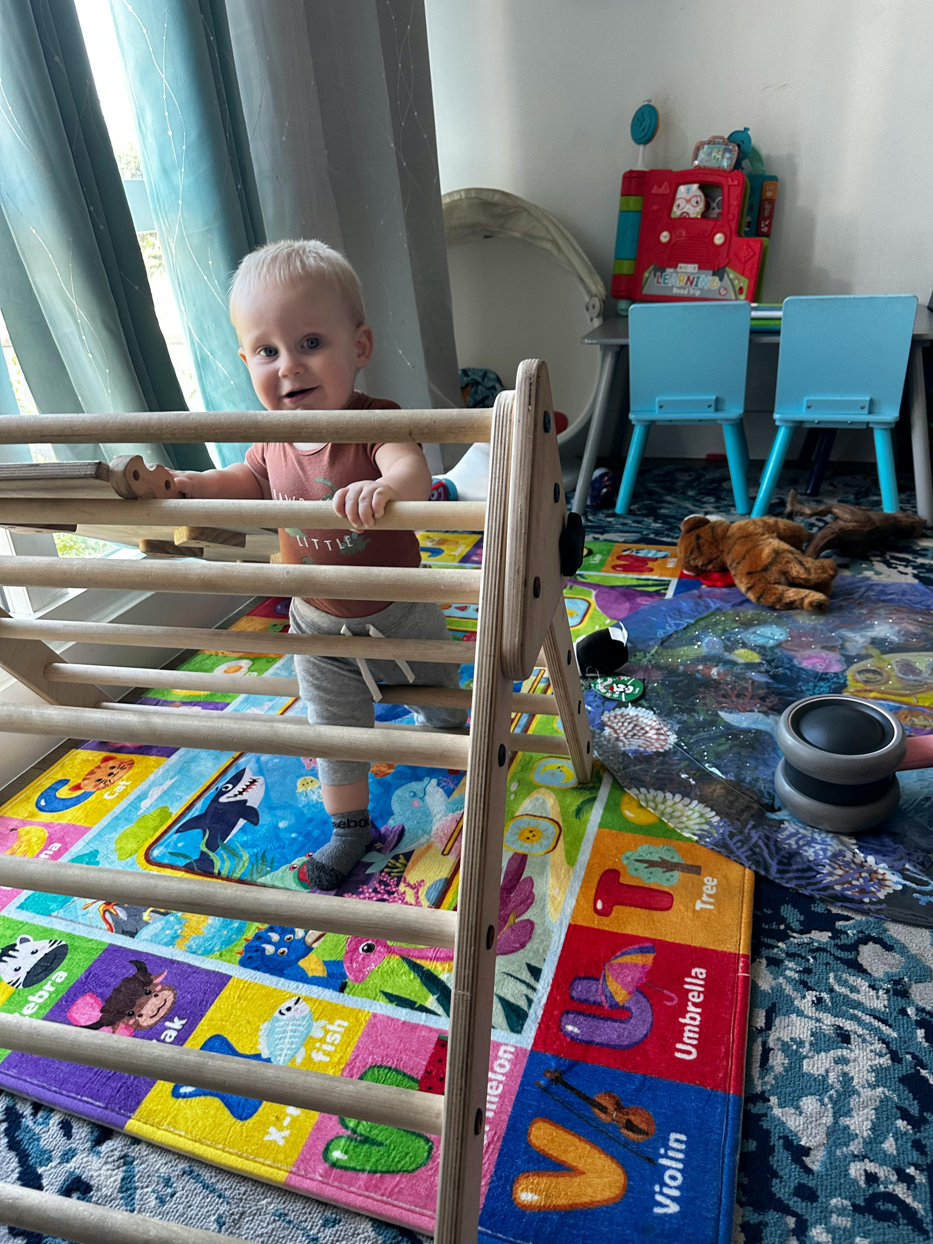 Child standing behind a wooden play structure