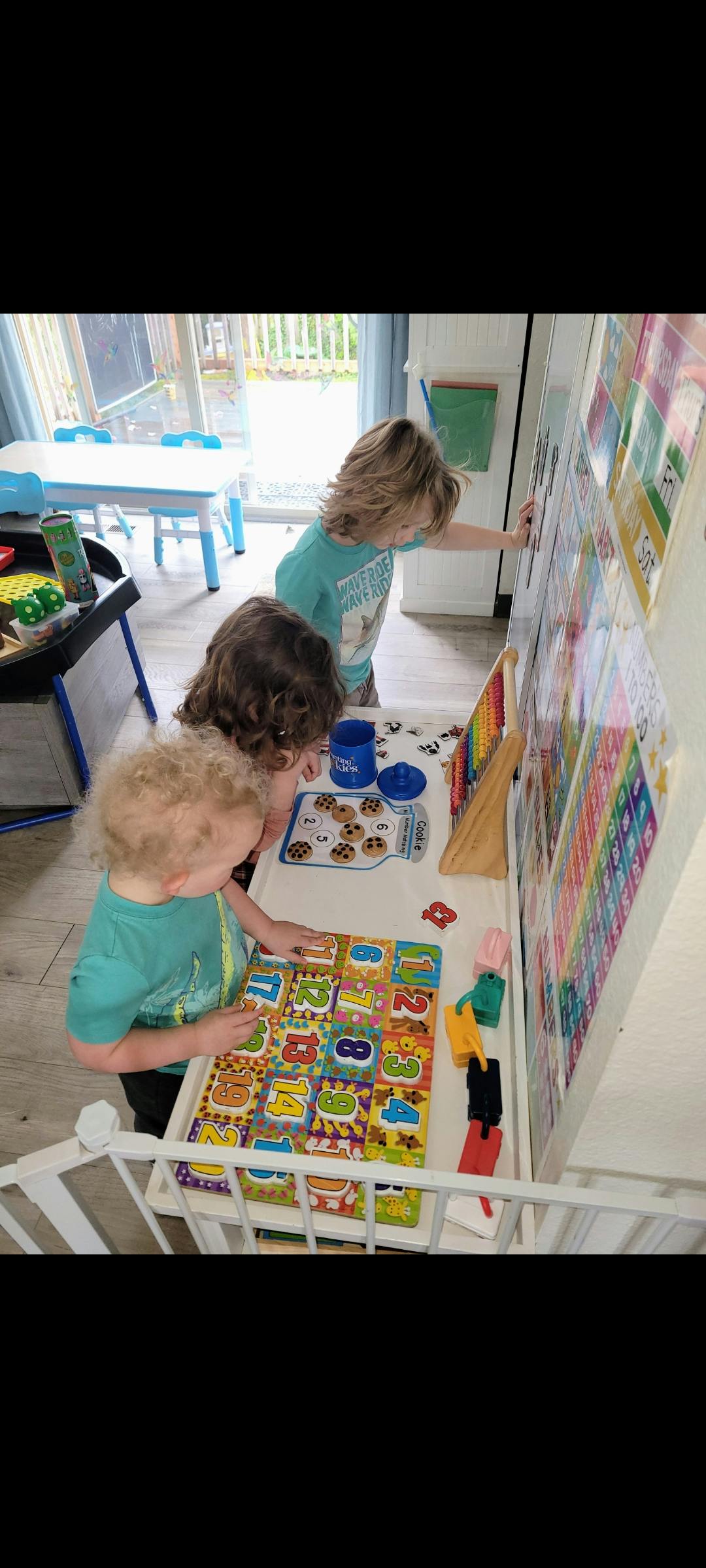 Three children playing with puzzles and toys in a room