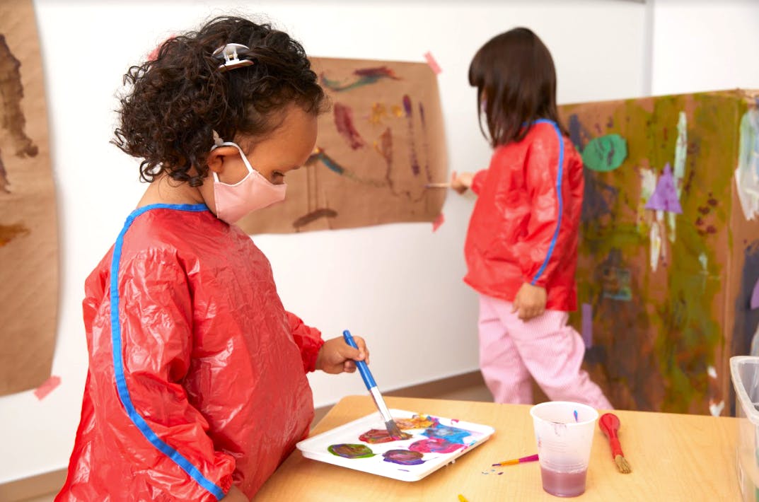 Two children painting in a classroom