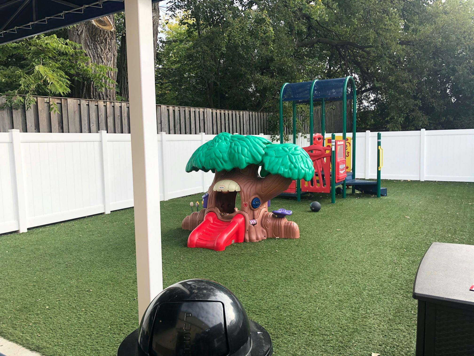 Playground with a tree-shaped slide and climbing structure on artificial turf