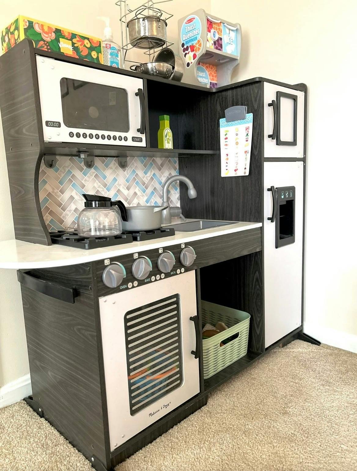 Child's play kitchen with microwave, stove, oven, and refrigerator