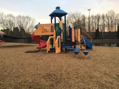 Colorful playground structure with slides on wood chip ground
