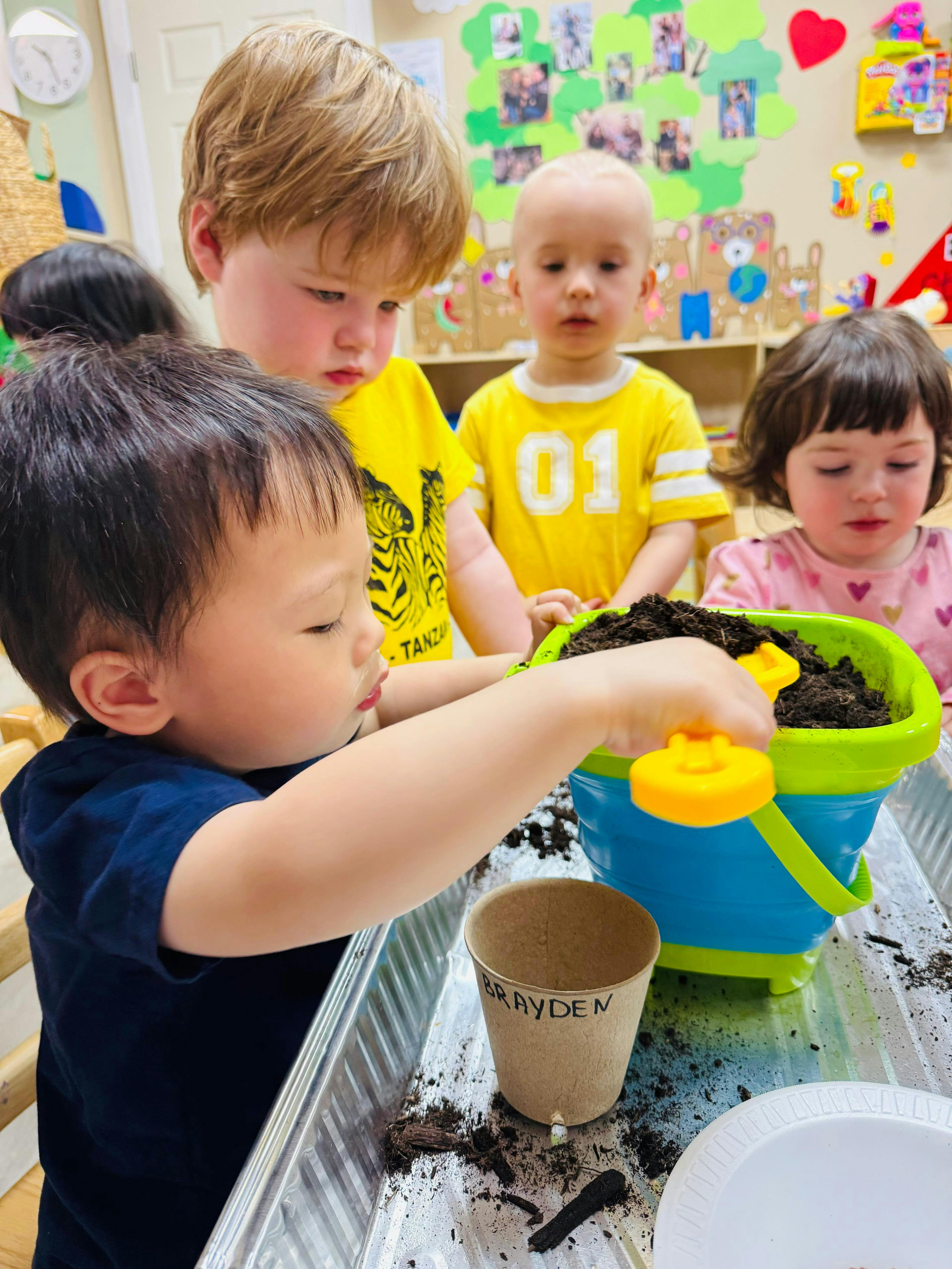 Children gardening with soil and pots in a classroom