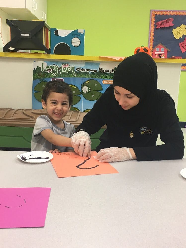 Person and child doing an art activity at a table