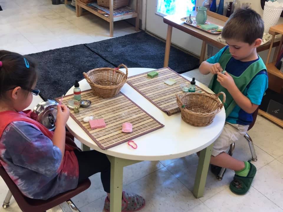 Two children sitting at a table, engaged in an activity