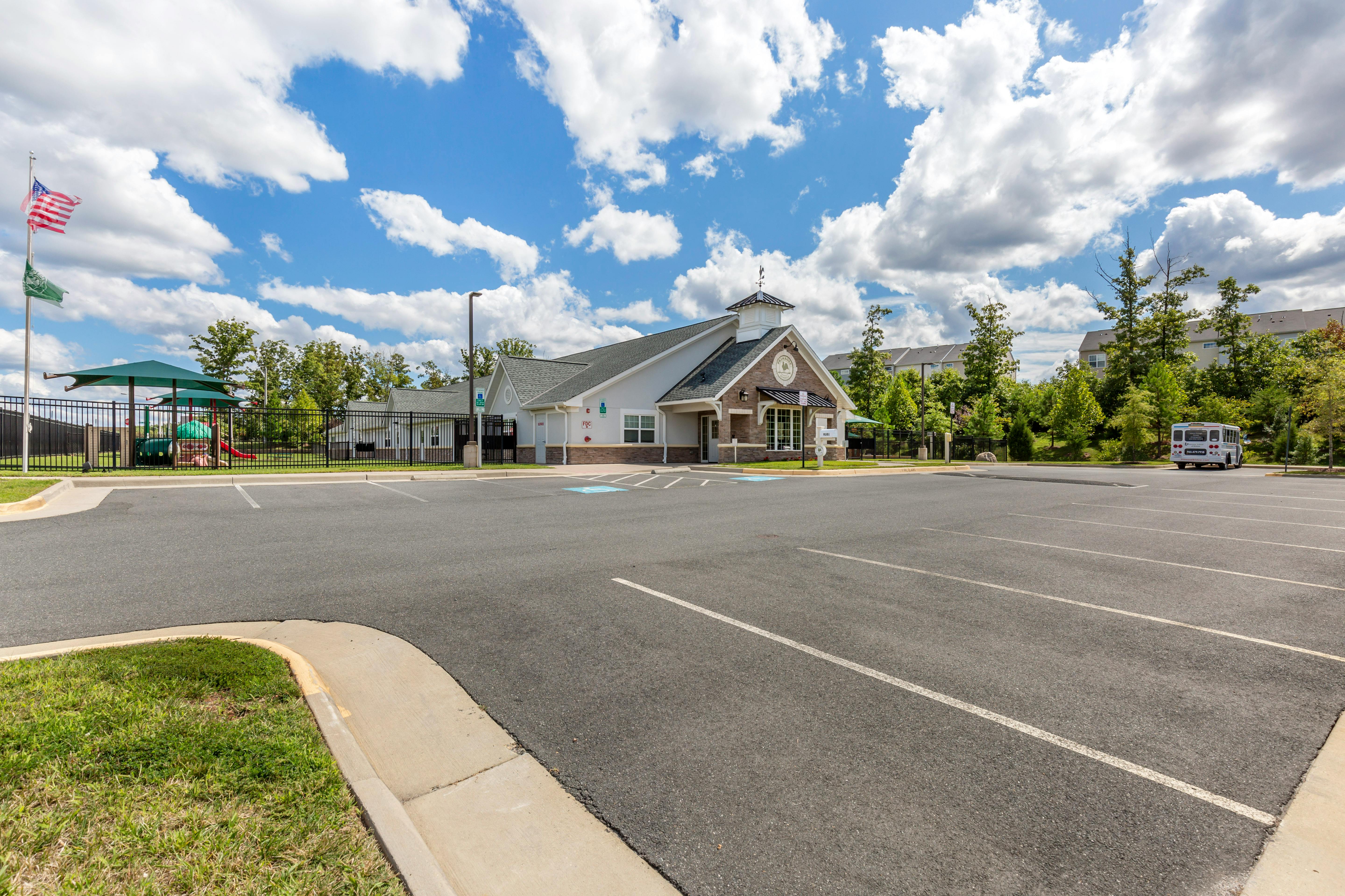 A school building with a large empty parking lot in front