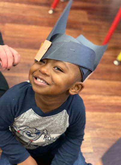Child wearing a paper hat
