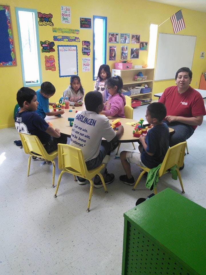 Adult and children sitting around a table in a classroom