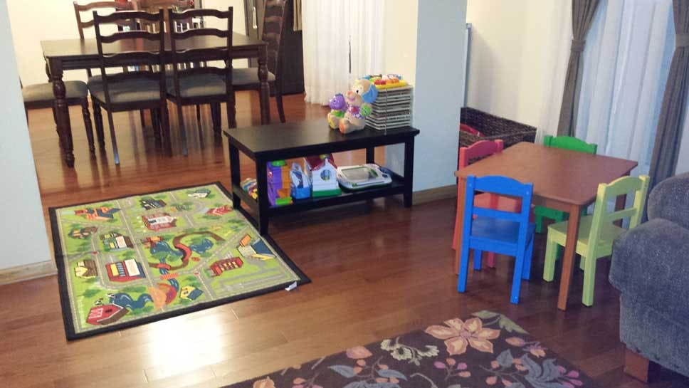 Playroom with small table and chairs, rug, and storage shelf
