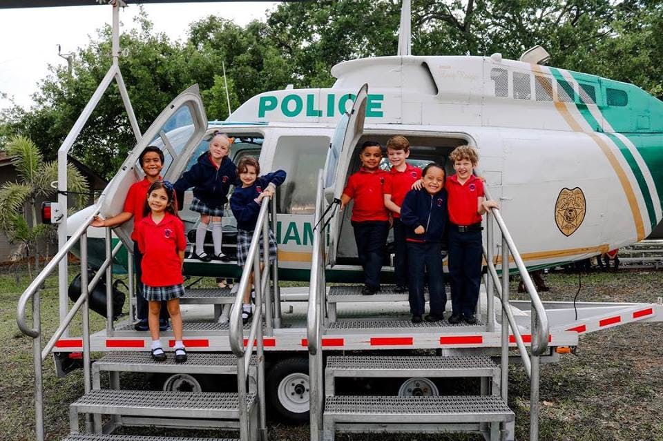 Children standing on the steps of a police helicopter