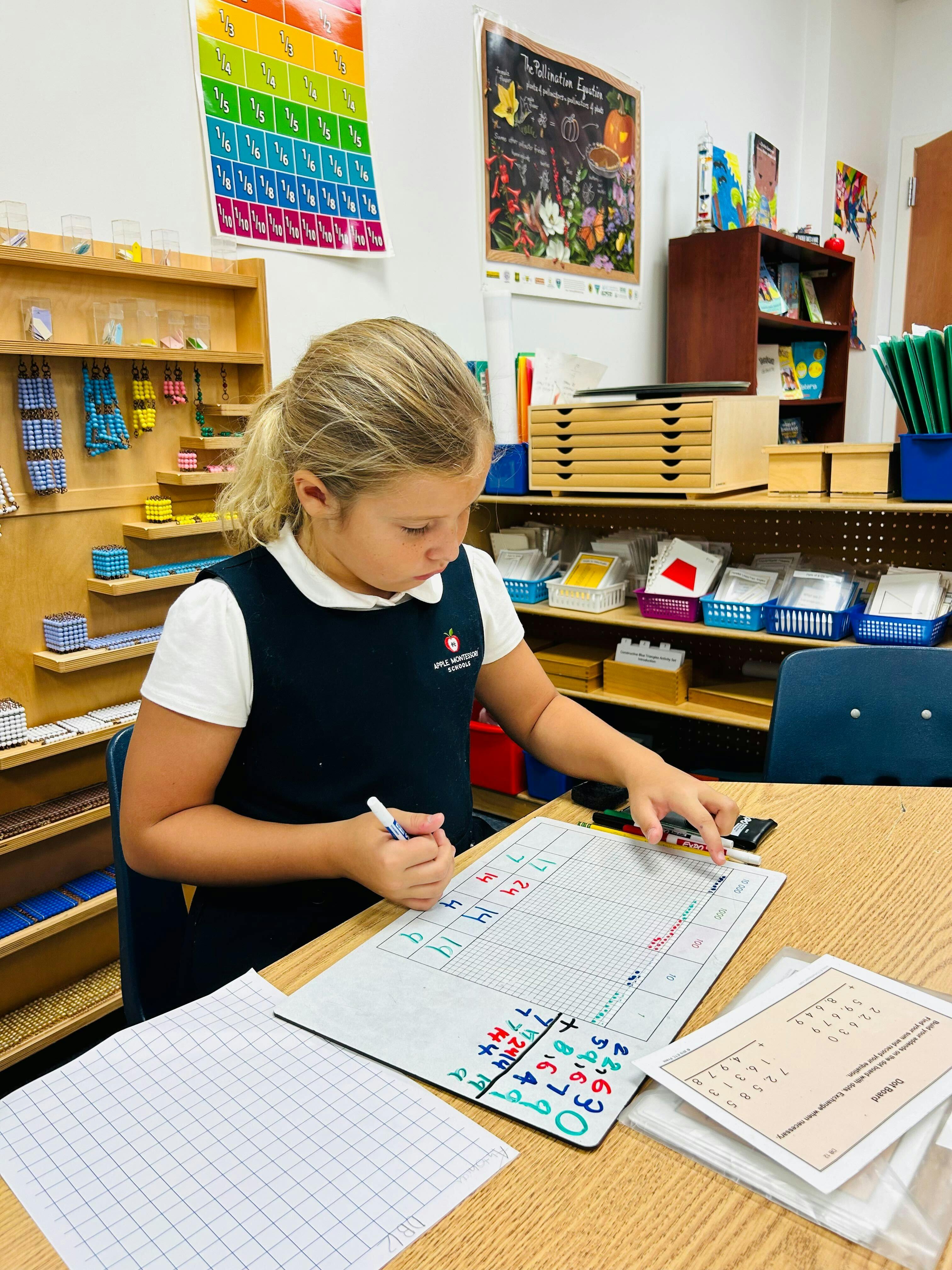 Child writing on a whiteboard with math problems in a classroom
