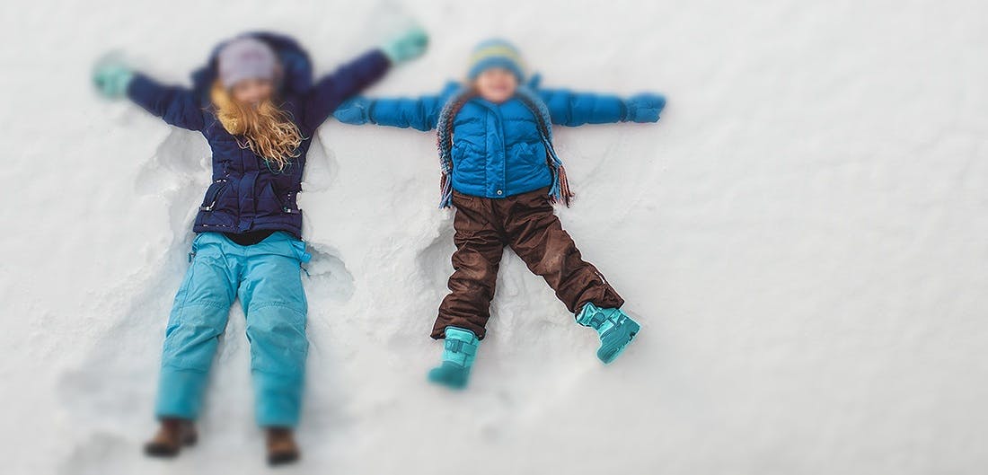 Two children making snow angels