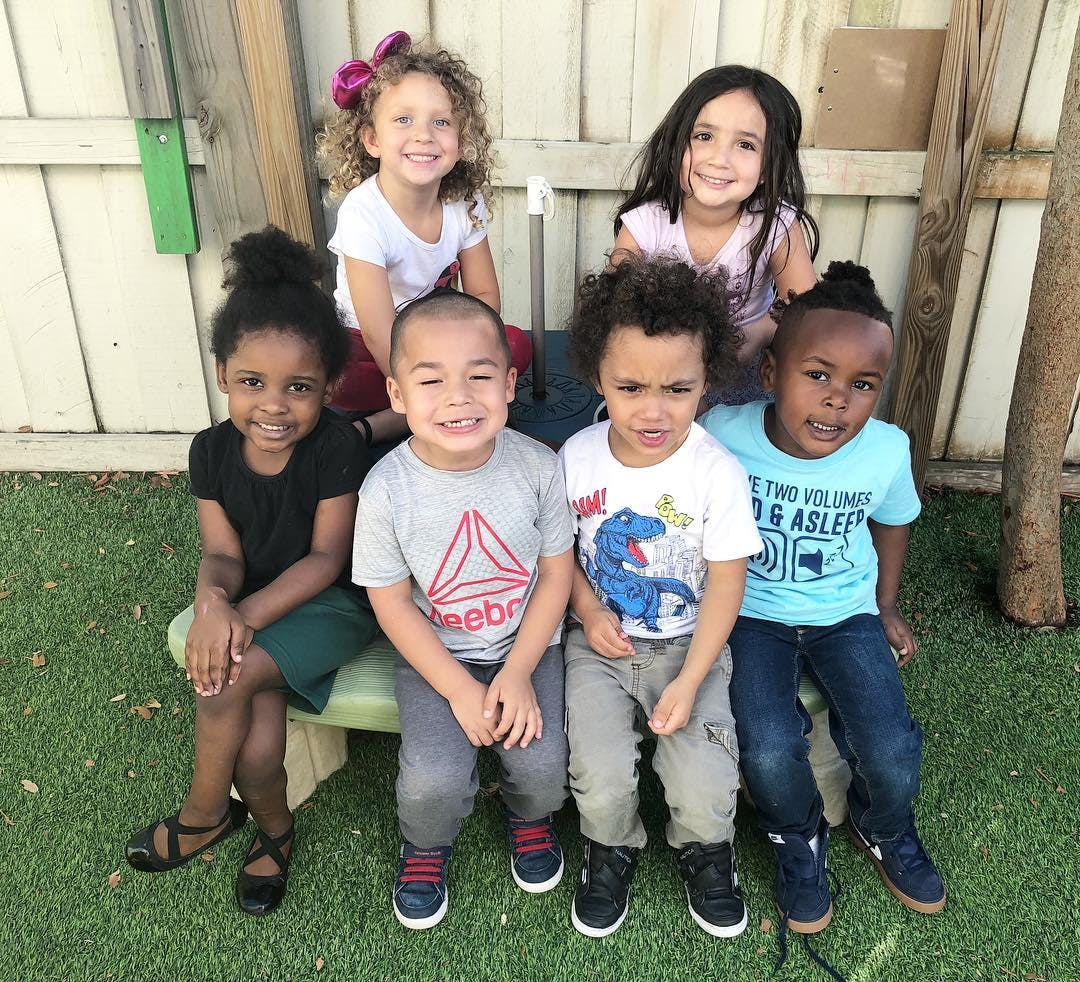 Six children sitting together outdoors
