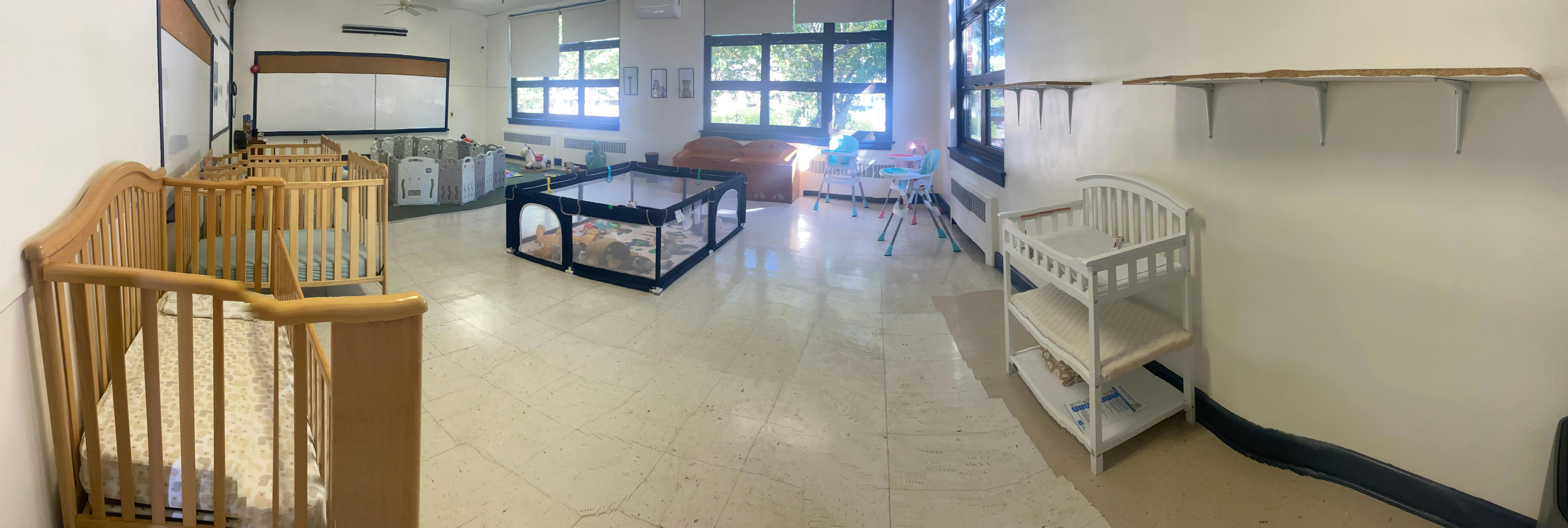 Empty room with multiple cribs and a playpen