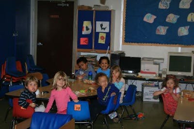 Group of children sitting at tables in a classroom
