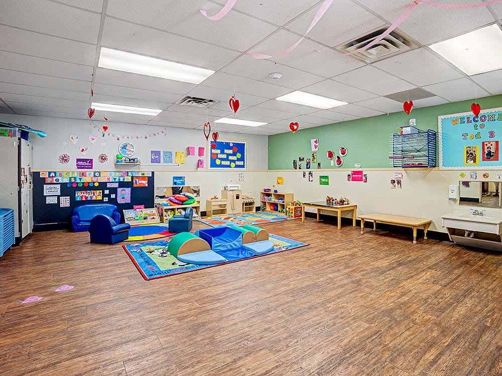 Playroom with small chairs, tables, and colorful rugs