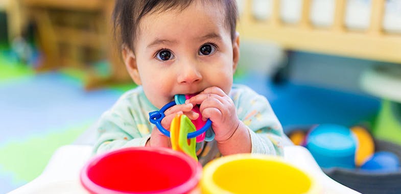 Child chewing on a colorful toy