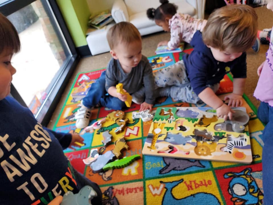 Children playing with puzzles on a colorful rug
