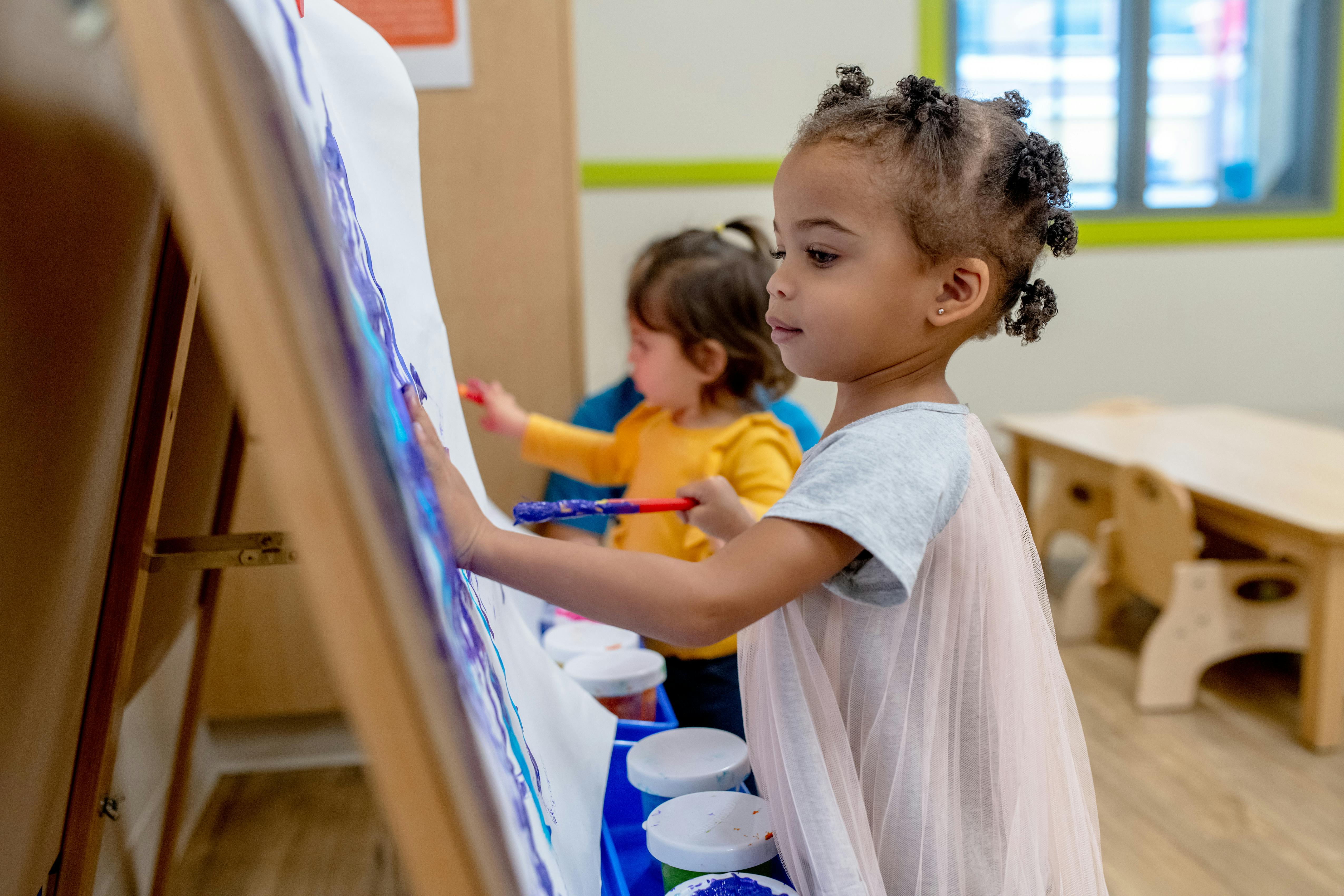 Child painting on an easel in a classroom