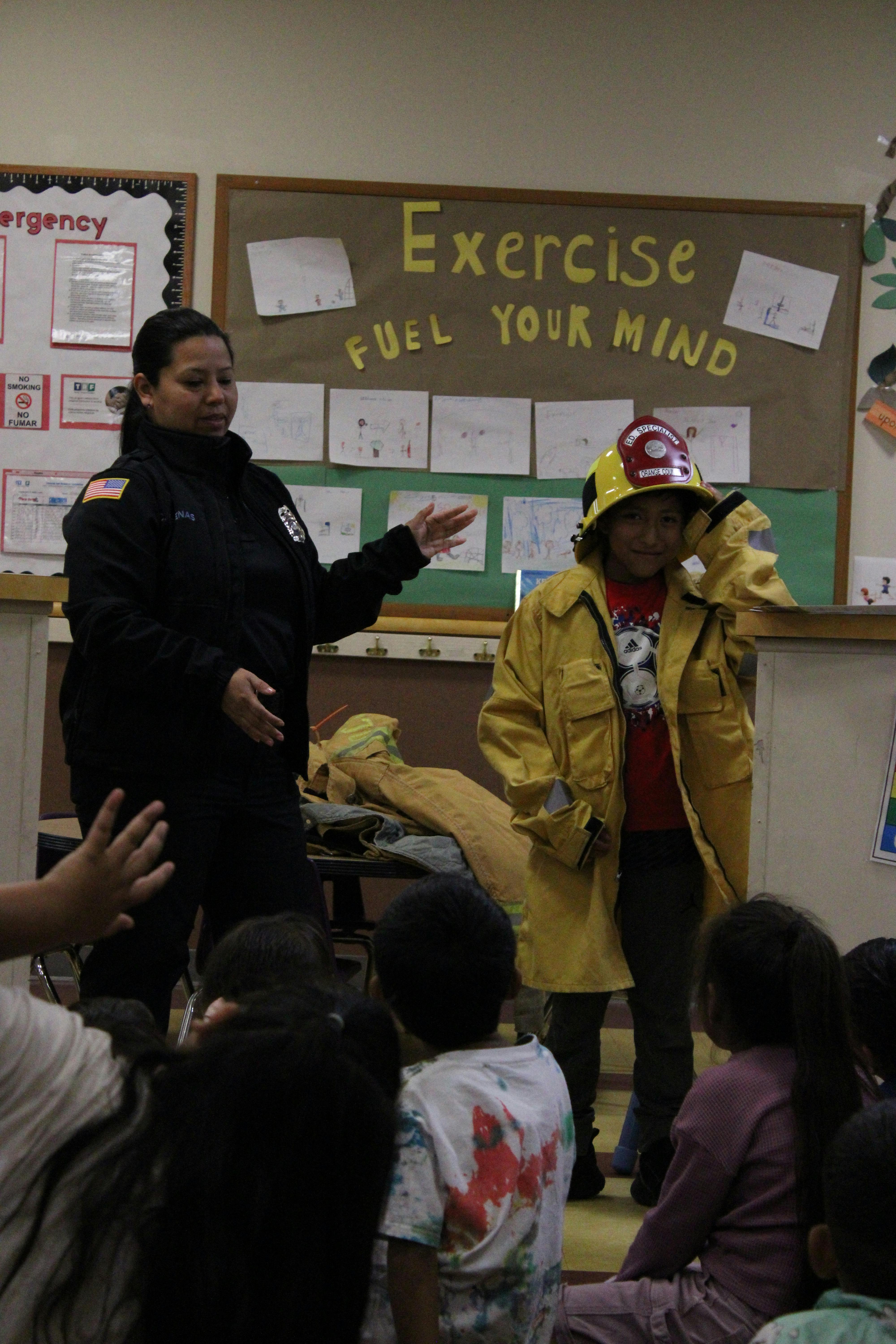Adult in black jacket with children, one child wears a firefighter's helmet