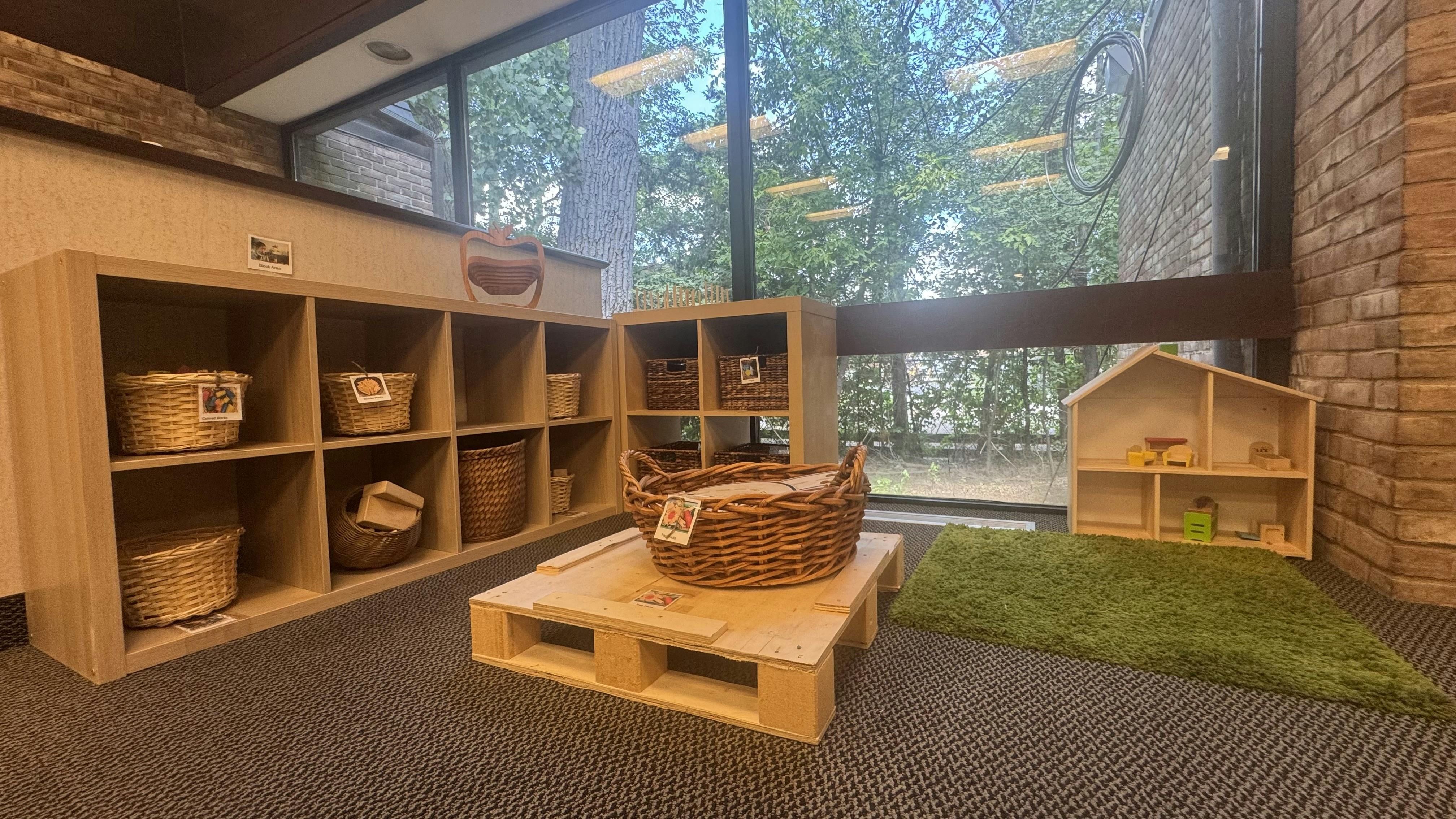 Classroom with wooden shelves, baskets, and a dollhouse