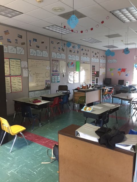 Empty classroom with desks, chairs, and decorated walls