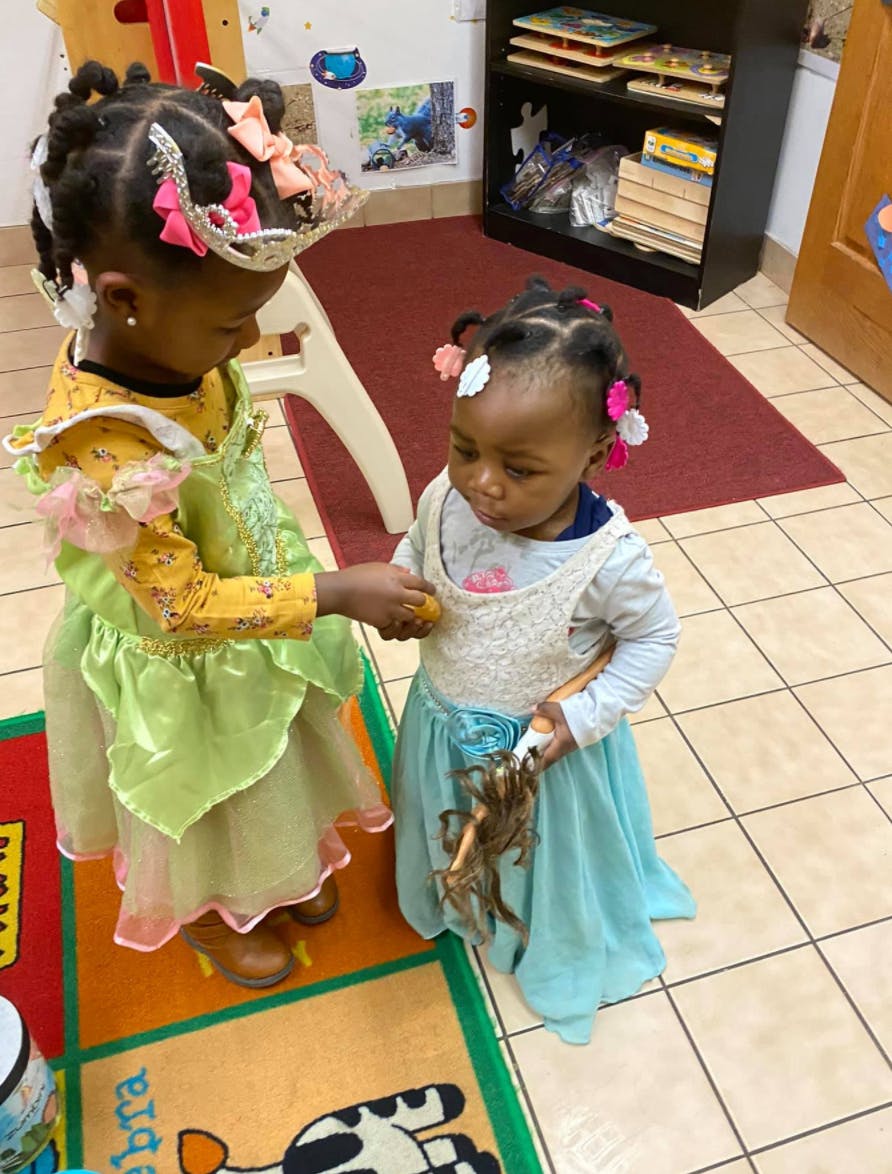 Two children in costumes holding hands