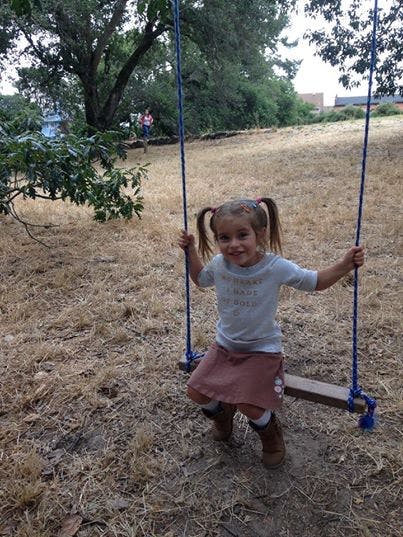 Child with pigtails on a swing