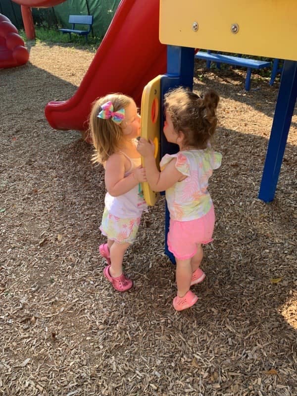 Two children playing on a playground structure