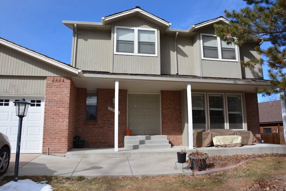 Two-story house with brick and siding, attached garage, and front porch