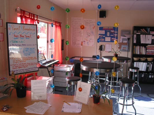Classroom with whiteboard, high-top tables, and colorful hanging decorations