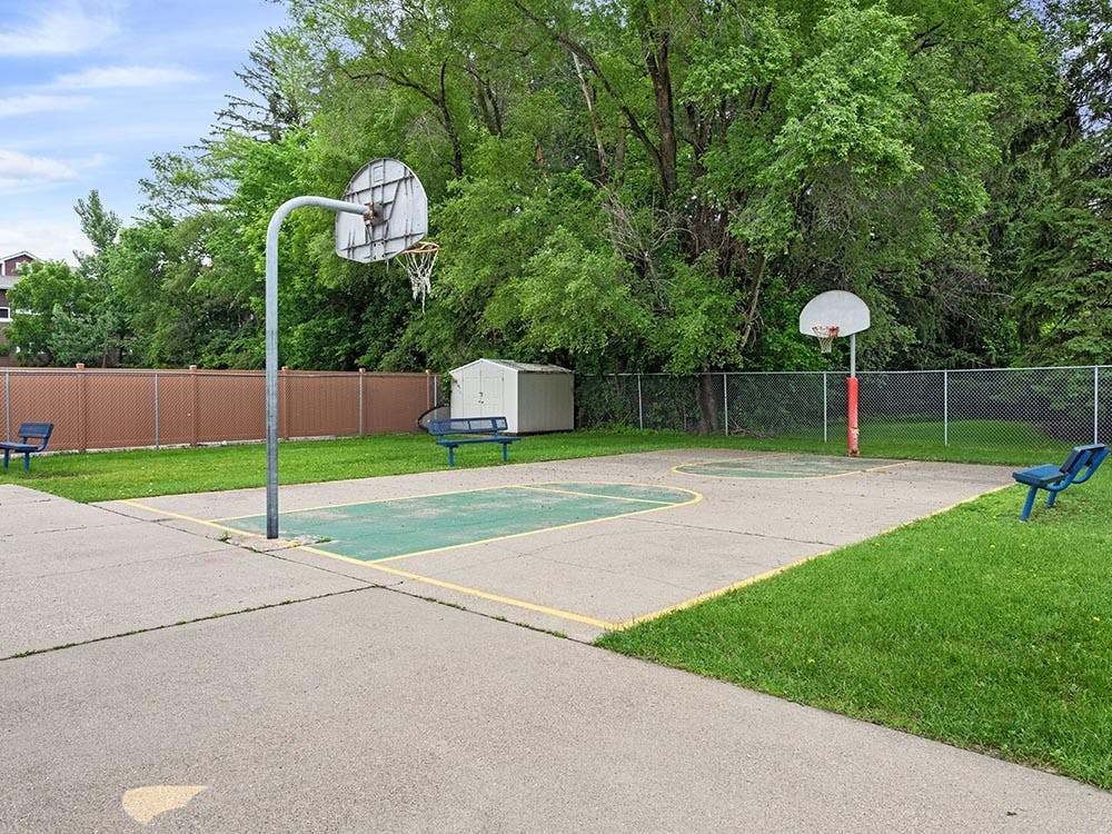 Outdoor basketball court with two hoops and benches