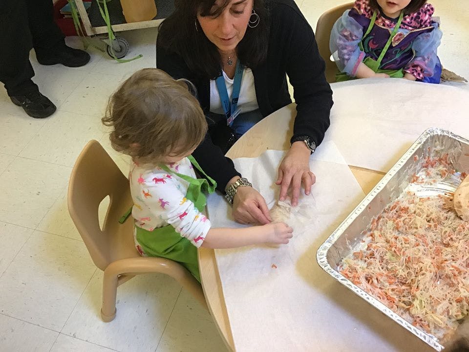 Adult and child making food together at a table