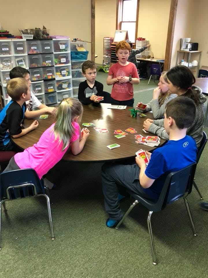 Children playing cards around a table
