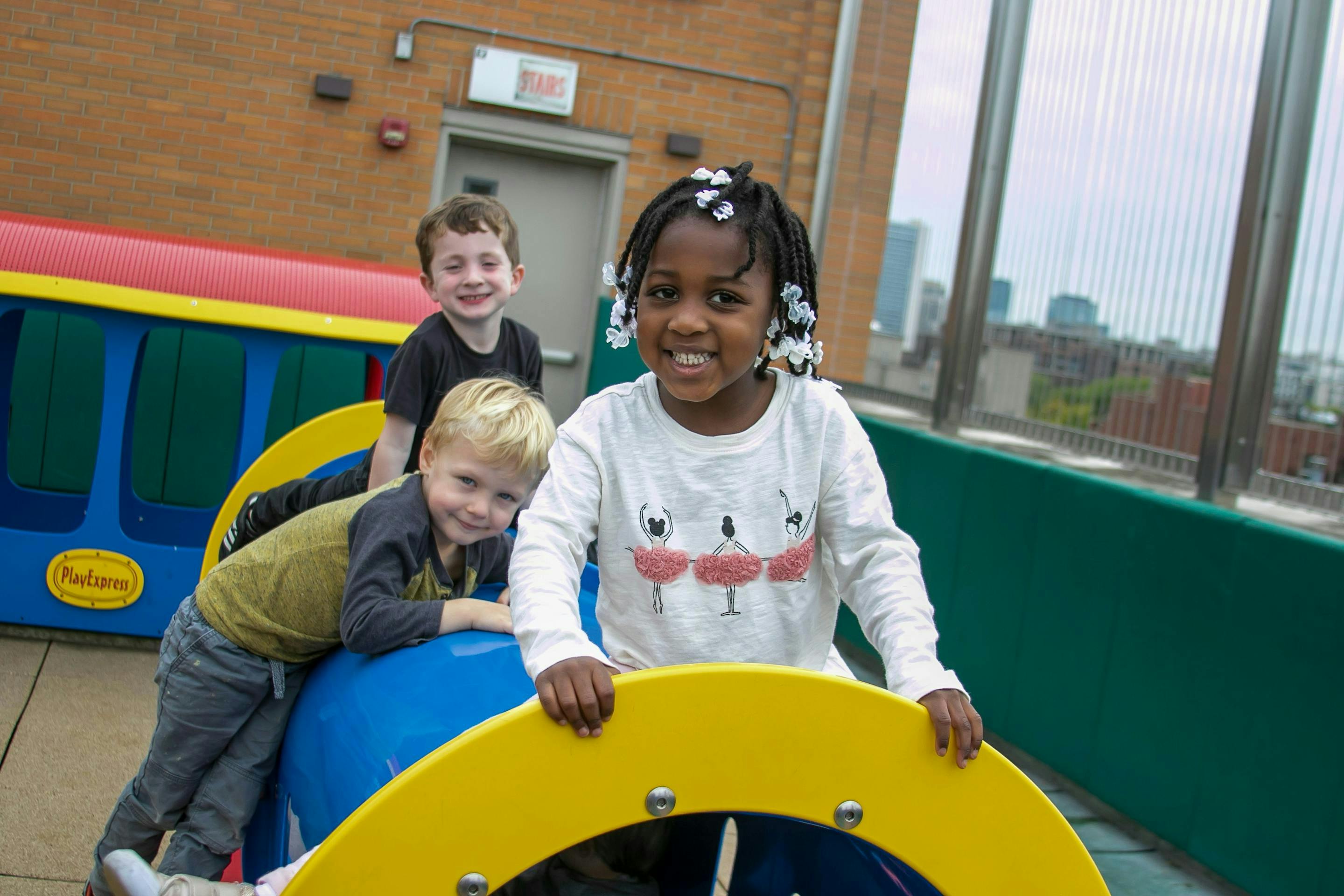 Three children playing on playground equipment