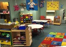 classroom with tables, chairs, and storage shelves