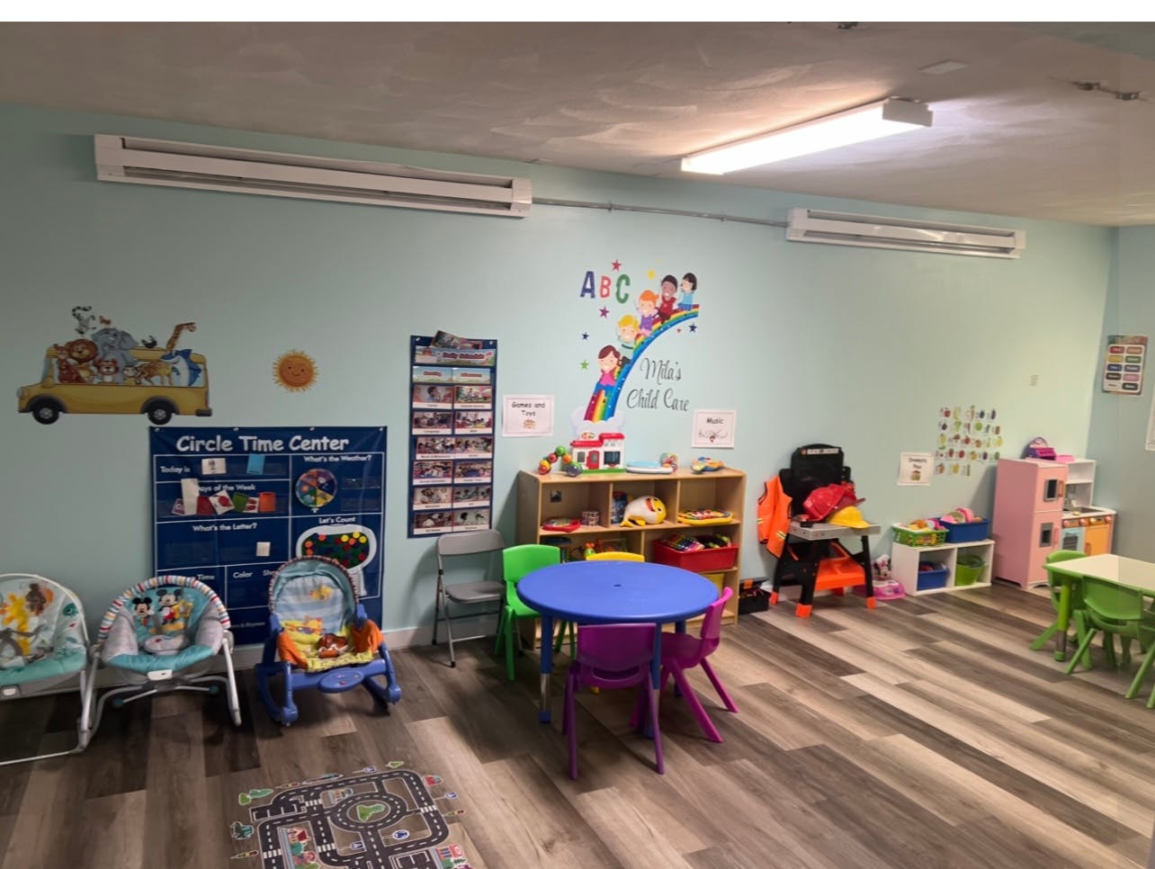 Children's playroom with small tables and chairs, toys, and wall decorations