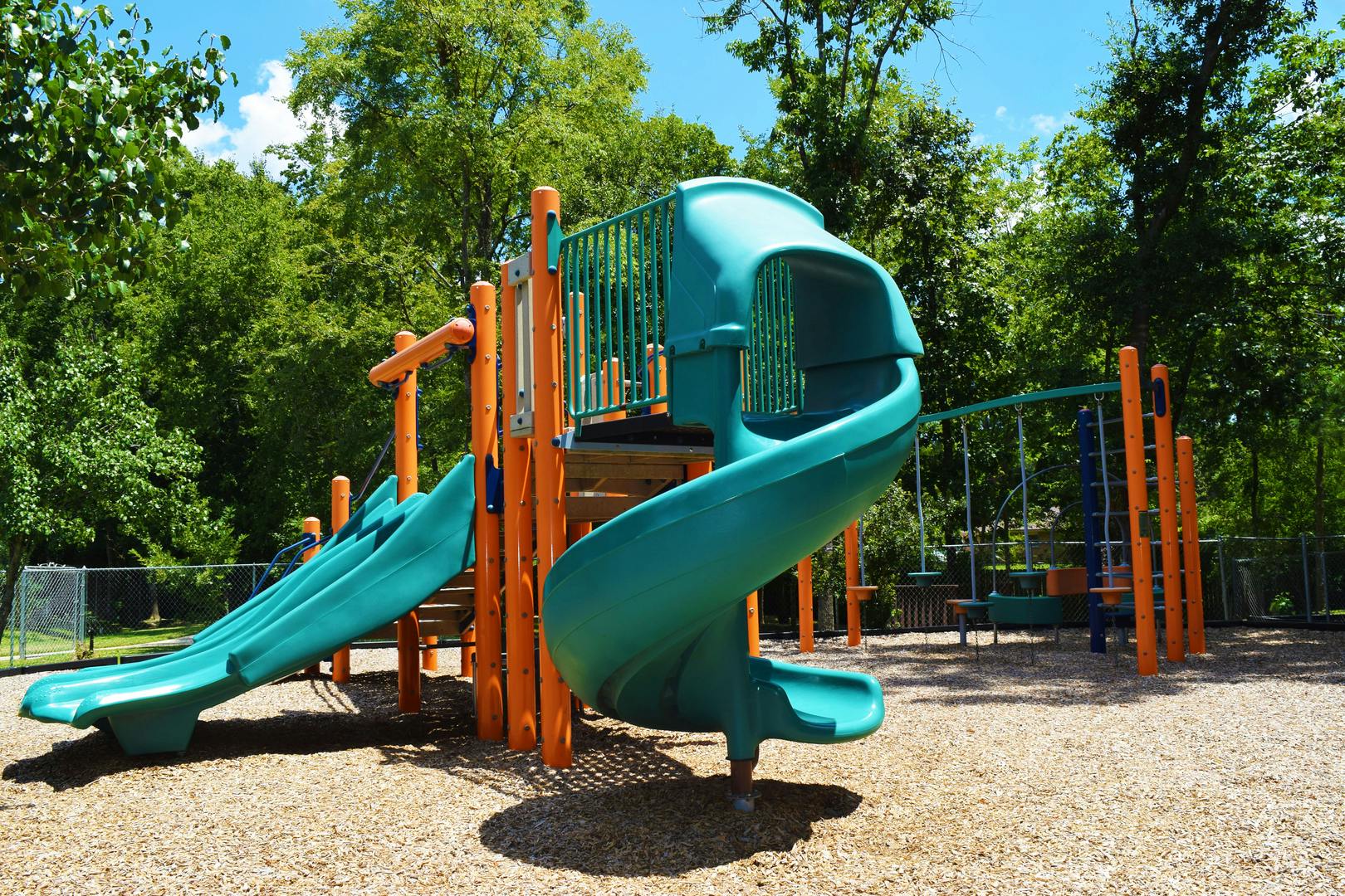 Playground with green slides and orange climbing structures