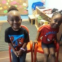 Two children sitting on chairs in a room