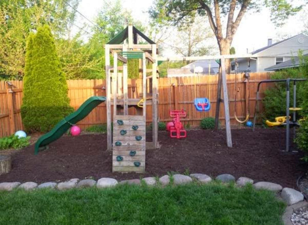 Outdoor playground with slide, swings, and climbing wall