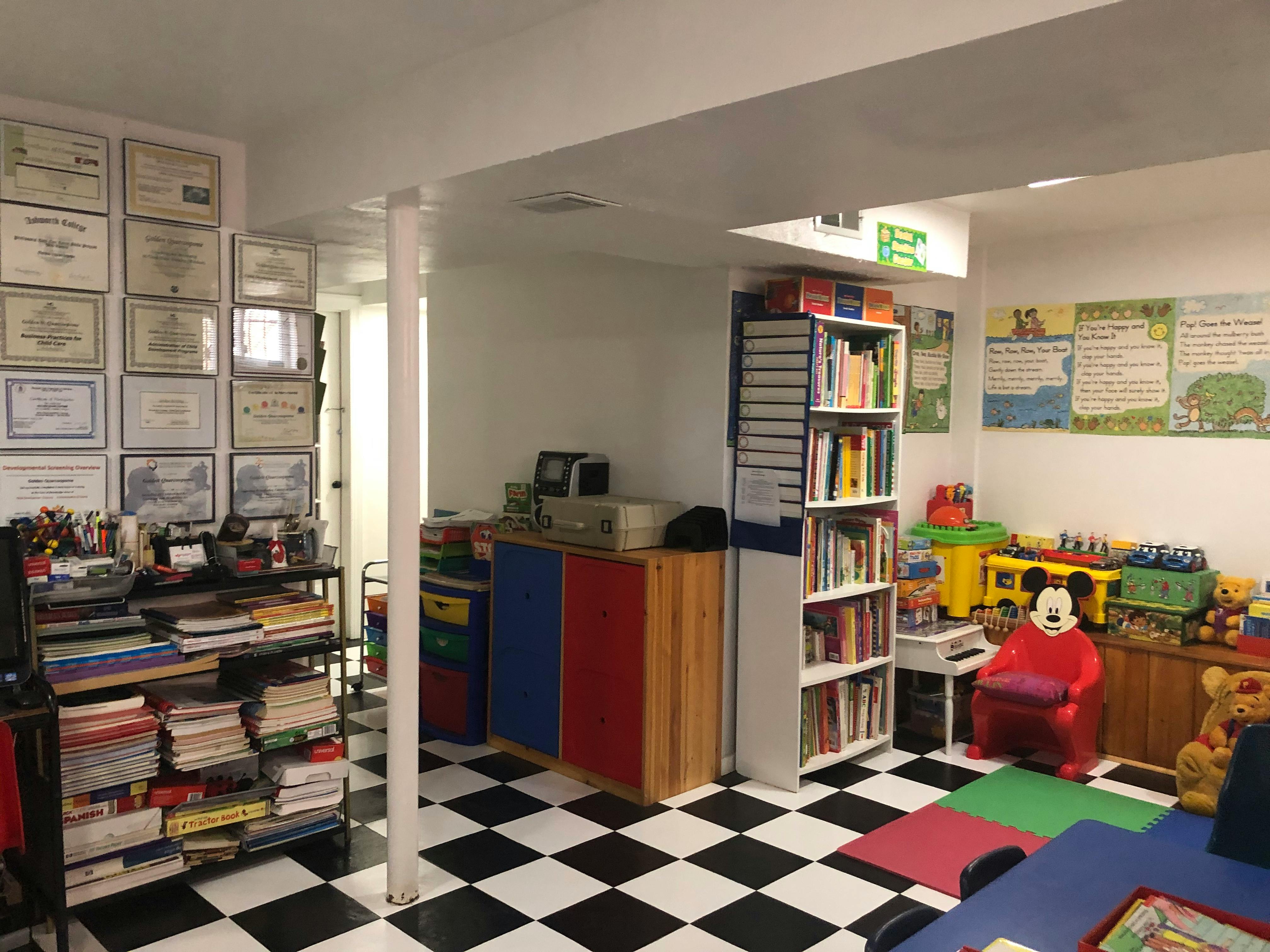 Room with black and white checkered floor, bookshelves, and children's toys