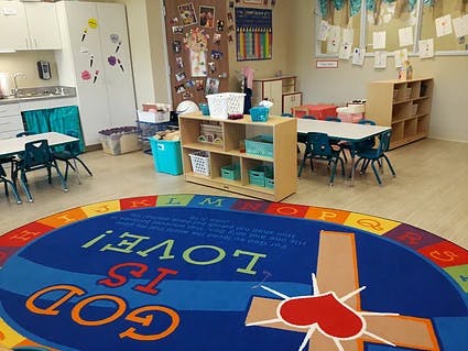 Classroom with a colorful rug that says "God is Love"
