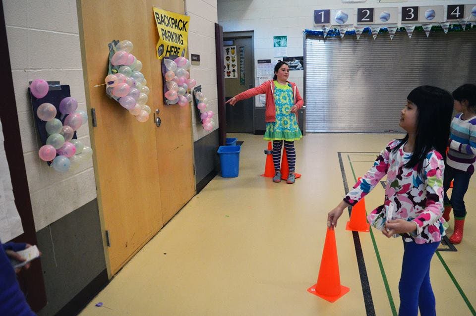 Child holding an orange cone, another child pointing