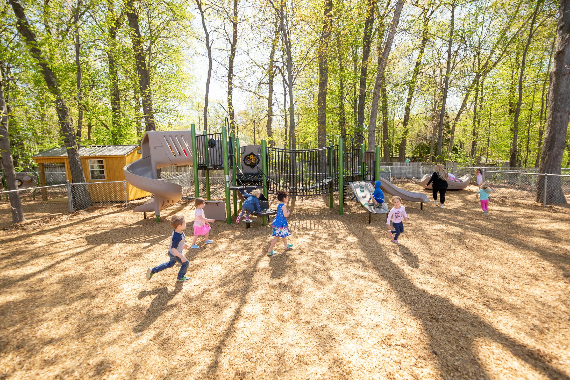 Children playing on a playground with slides and climbing structures
