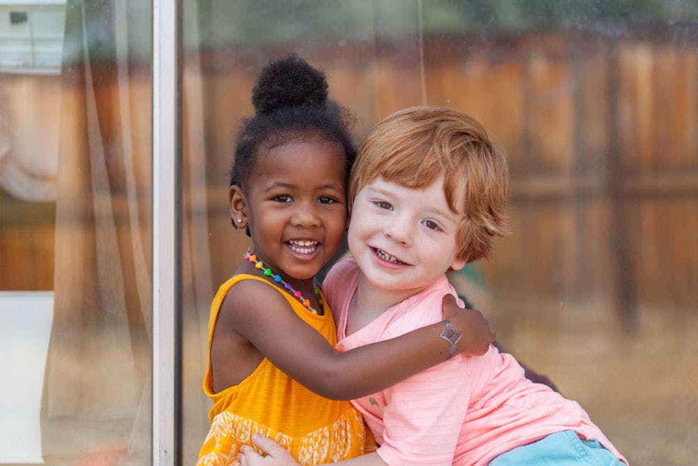 Two children embracing and smiling