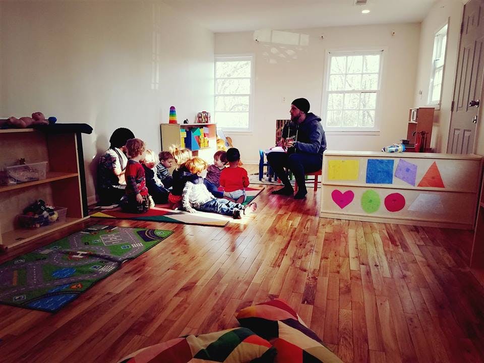 Adult reading to children in a classroom
