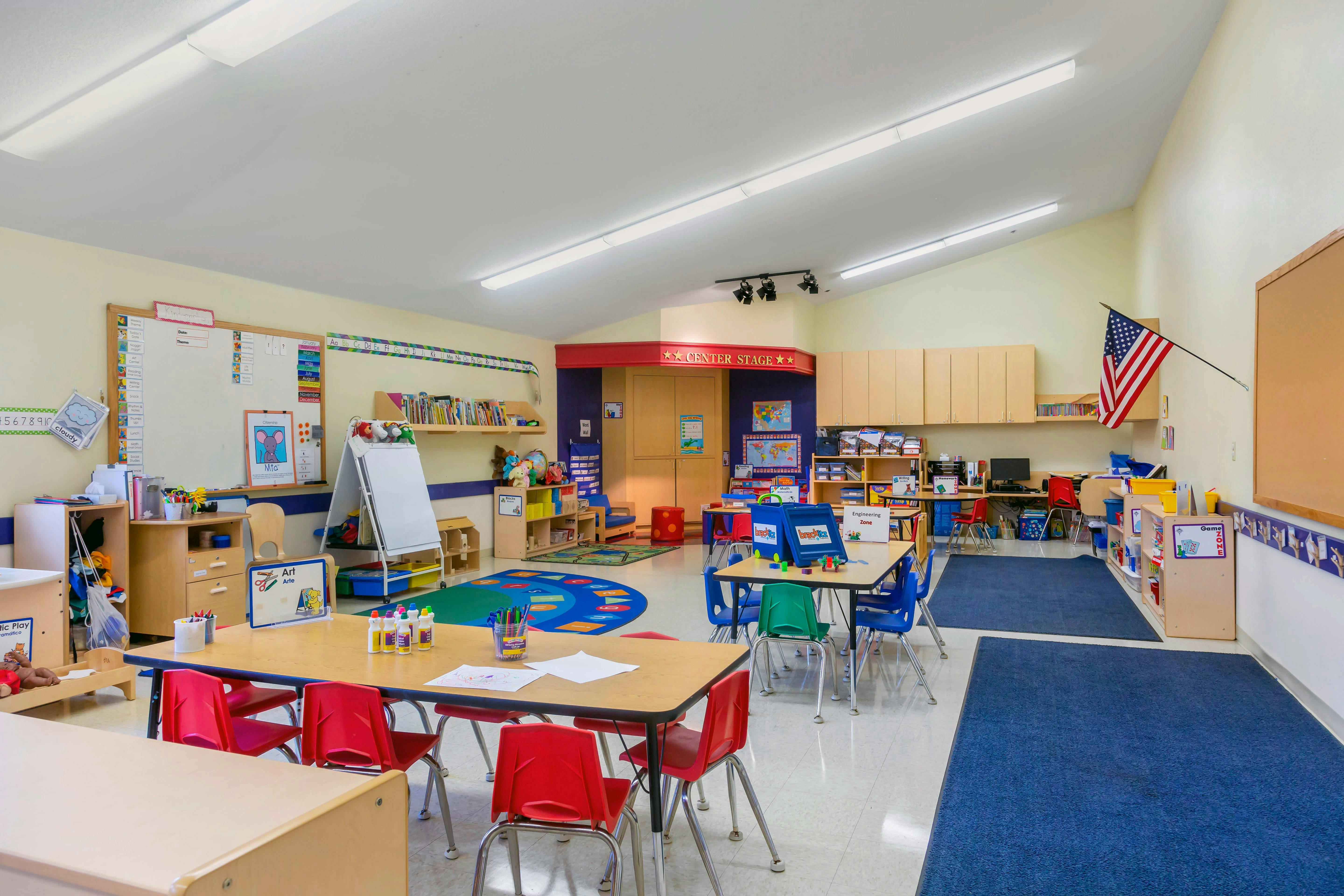 A colorful and bright classroom with small tables, chairs, and learning materials