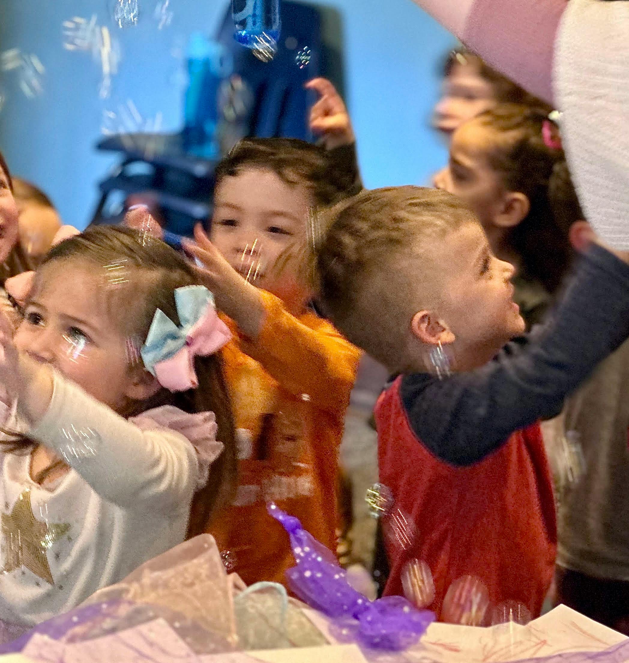 Children reaching for bubbles