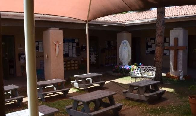 Outdoor courtyard with picnic tables and religious statues