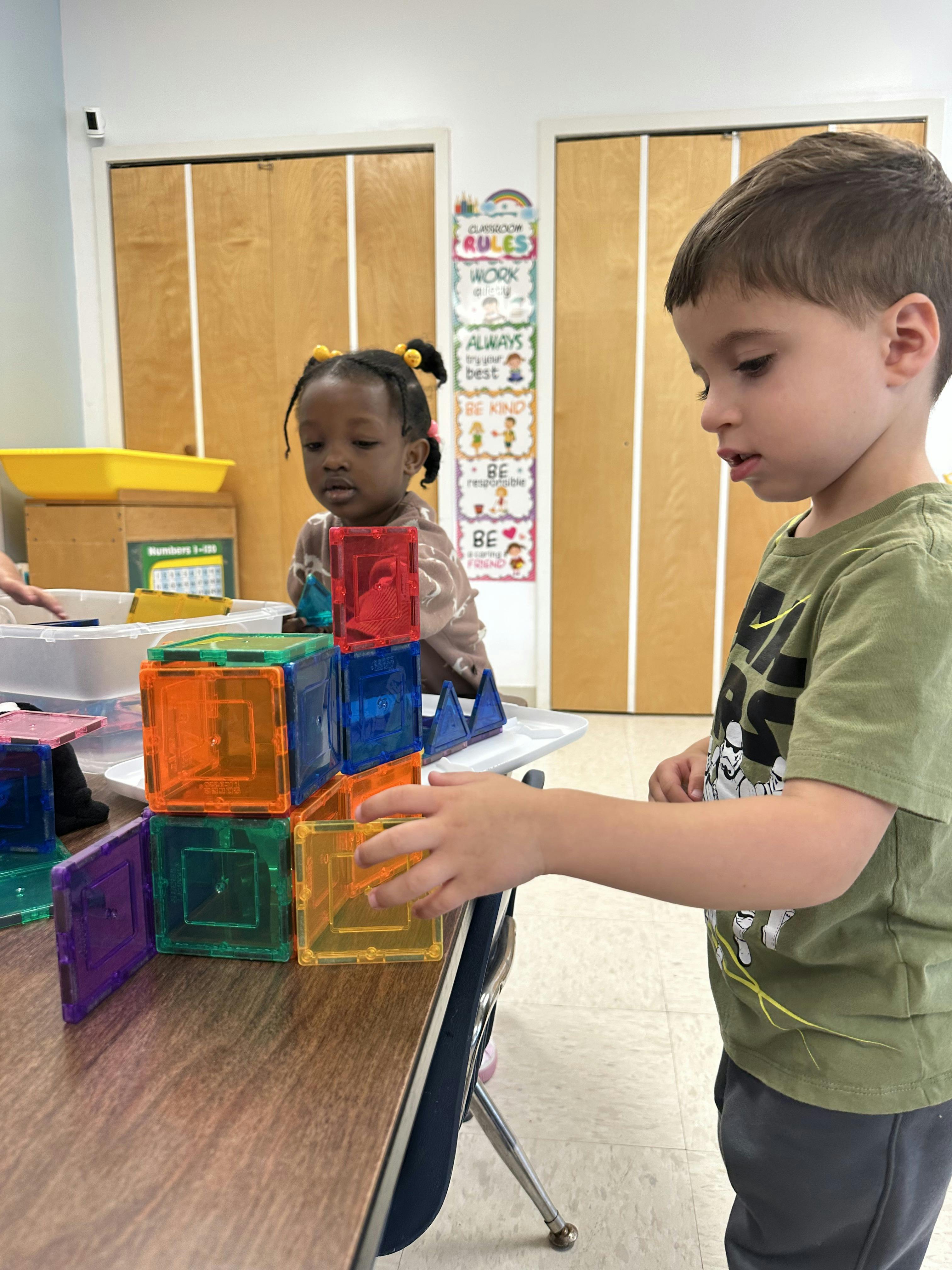 Child building with colorful magnetic blocks in a classroom